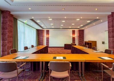 Besprechungsraum mit Stühlen, Tisch und Wandpaneelen aus Holz.